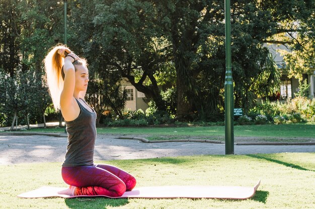 Woman on stretching mat making ponytail