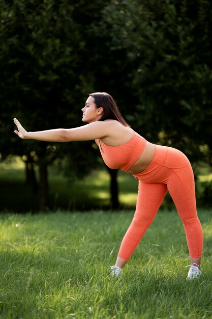 Woman stretching in nature full shot