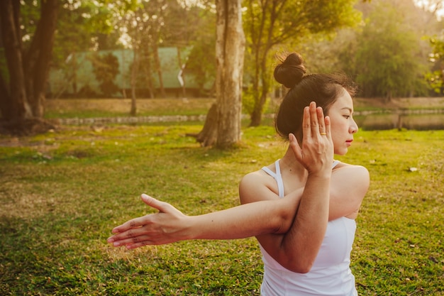 Free photo woman stretching in the nature with the sunset