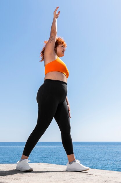 Woman stretching outdoors full shot