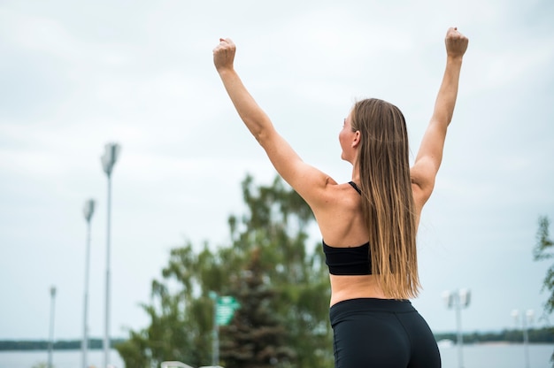 Foto gratuita donna che allunga al colpo medio del parco