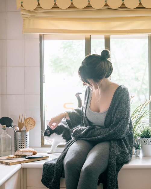 Woman stroking her cat in kitchen