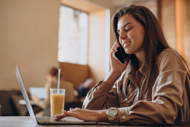 Woman student studying on laptop in a cafe