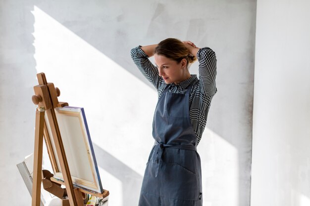 Woman at studio with canvas and easel
