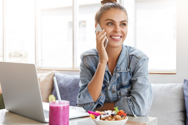 Woman in stylish denim jacket in coffee shop