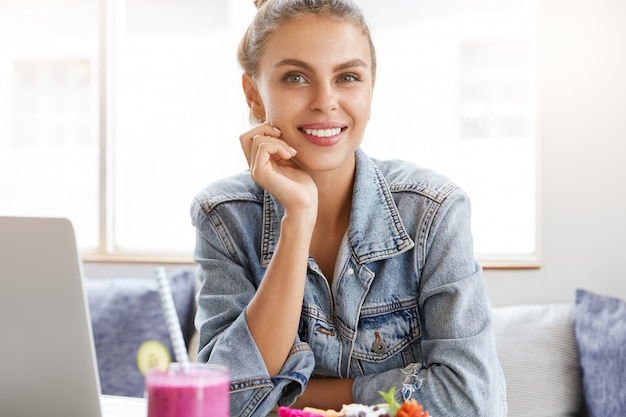 Free photo woman in stylish denim jacket in coffee shop