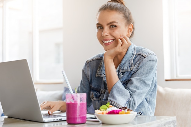 Woman in stylish denim jacket in coffee shop