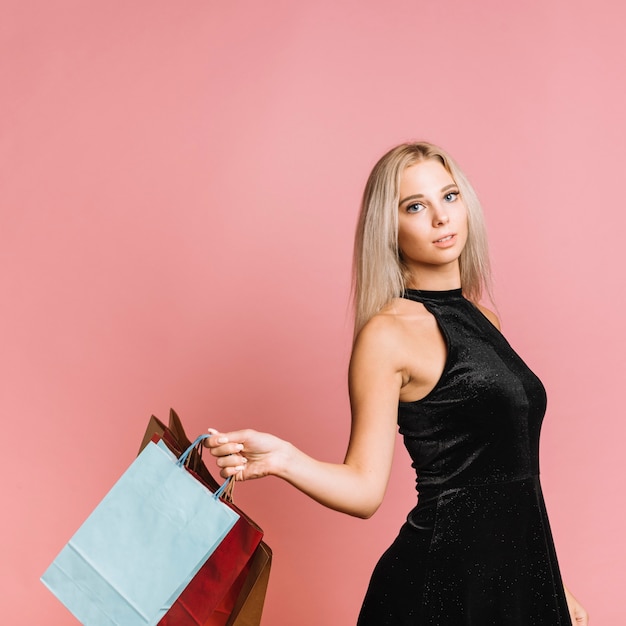 Woman in stylish dress with shopping bags 