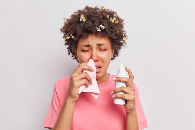 woman suffers from seasoanl allergy blows nose in napkin uses aerosol has health problems red eyes reacts on allergen isolated over white 