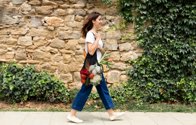 Free photo woman suing a sustainable bag for groceries