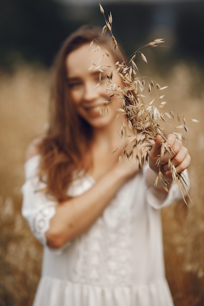 Woman in a summer field. Brunette in a white dress. 