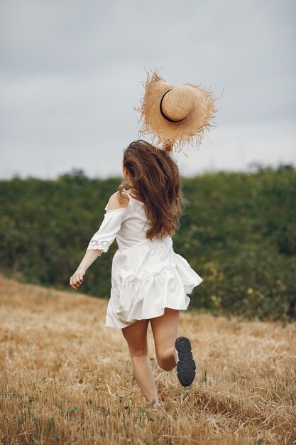 Woman in a summer field. Lady in a white dress. 