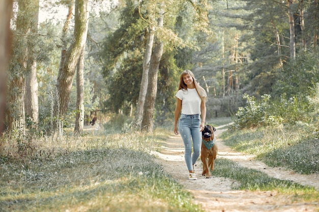 woman in a summer forest playing with dog