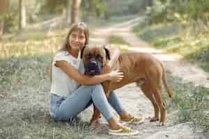 Foto gratuita donna in un bosco estivo a giocare con il cane