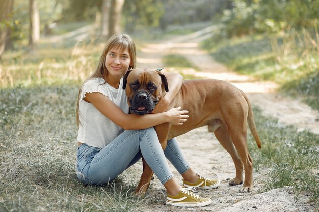 woman in a summer forest playing with dog