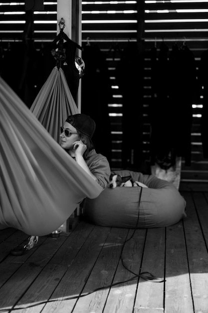 A woman in sunglasses lies in a red hammock