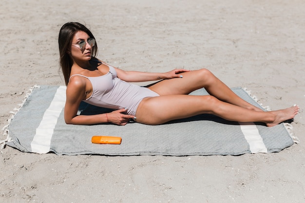 ビーチに横たわるサングラスの女性