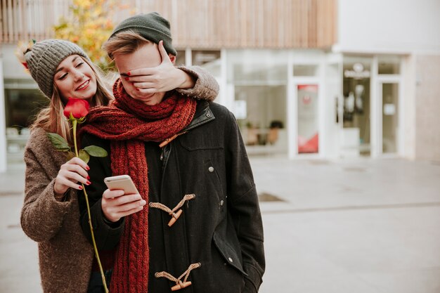 Woman surprising man with rose