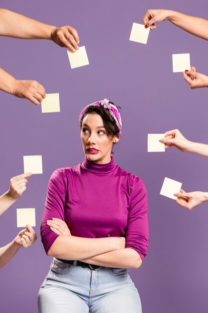 Woman surrounded by hands and sticky notes being anxious