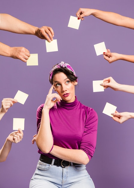 Woman surrounded by hands and sticky notes being bored