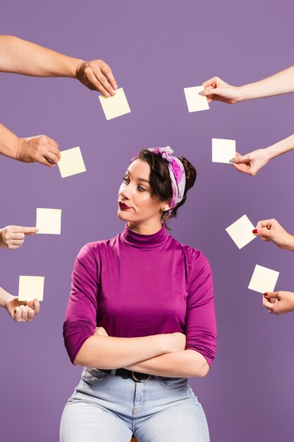 Woman surrounded by hands and sticky notes sitting
