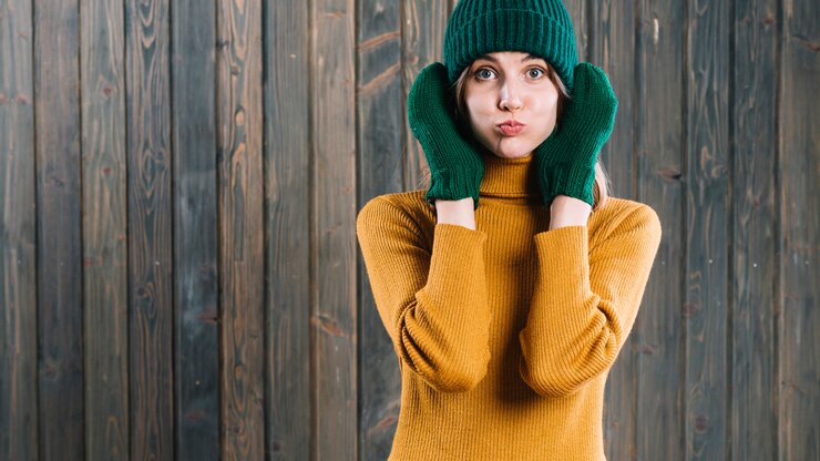 Free Photo woman in sweater blowing cheeks 