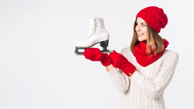 Woman in sweater holding white skate