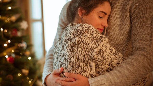 Woman in sweater hugging man