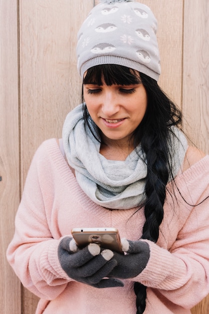 Donna in maglione guardando smartphone