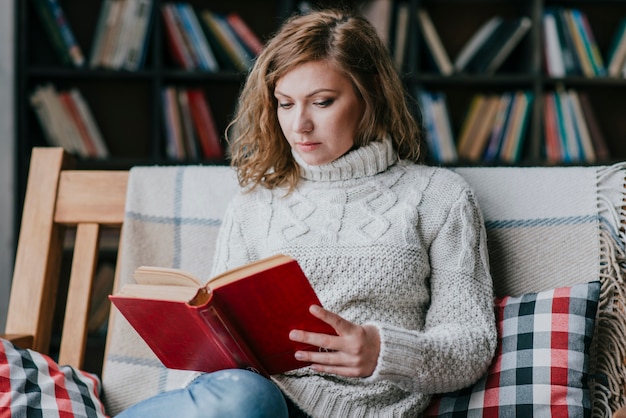 Woman in sweater reading book