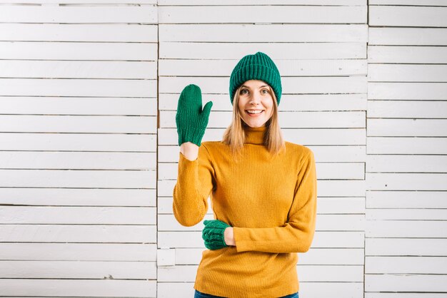 Woman in sweater showing greeting gesture 