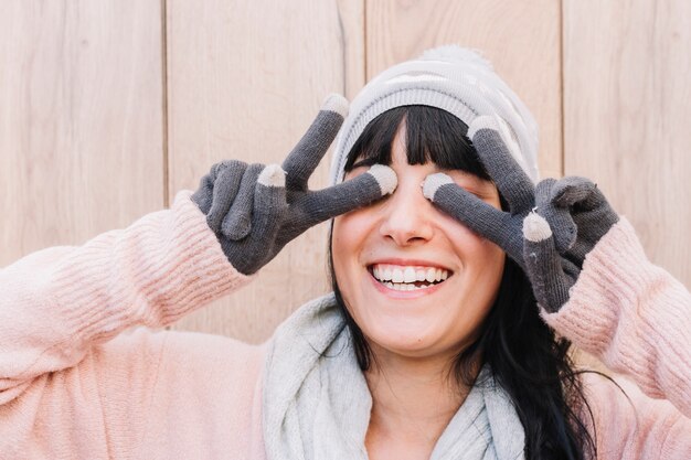 Free photo woman in sweater showing peace gesture