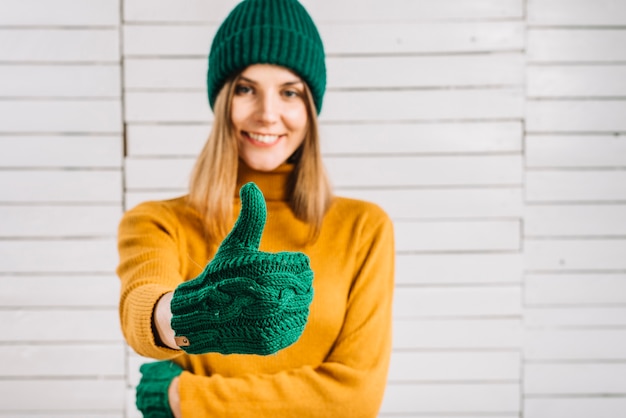 Woman in sweater showing thumb up
