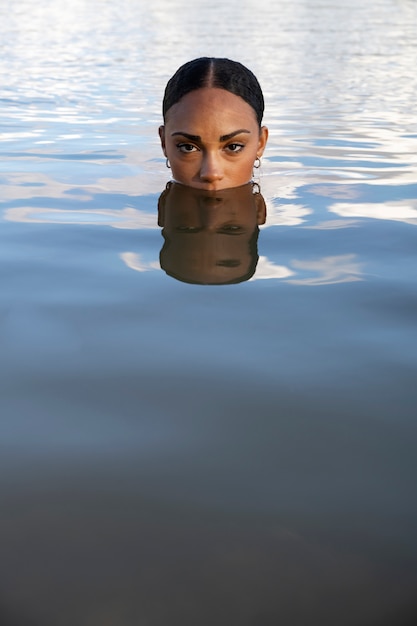 湖の正面図で泳いでいる女性