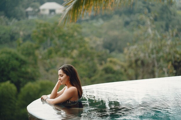 Woman in a swimming pool on a jungle view