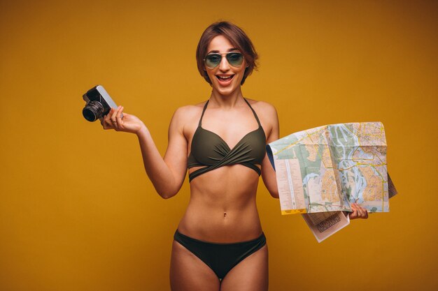 Woman in swimming suit with camera and travel map isolated