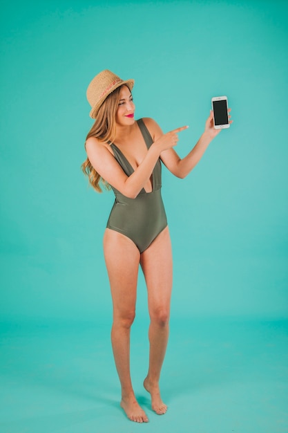 Woman in swimsuit pointing at her smartphone