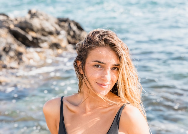 Woman in swimsuit standing on sea shore