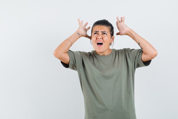 woman in t-shirt raising hands and looking agitated