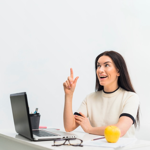 Woman at table pointing finger up