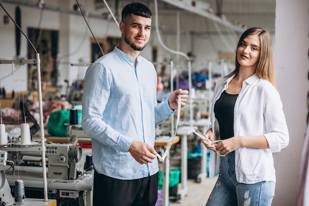 Woman tailor at a factory with a customer