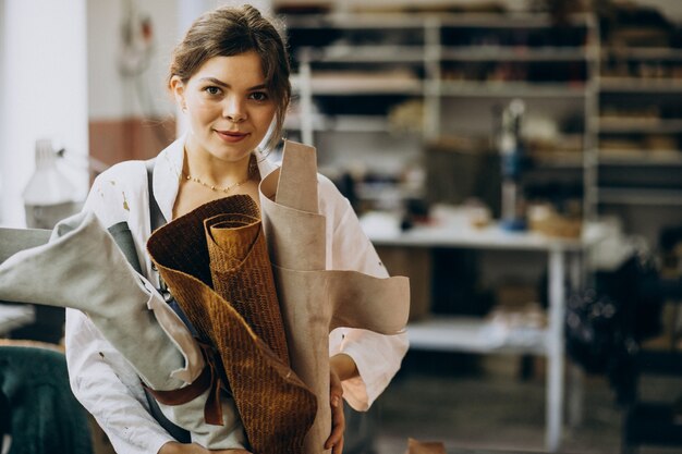 Woman tailor working on leather fabric