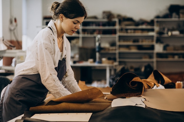 Woman tailor working on leather fabric