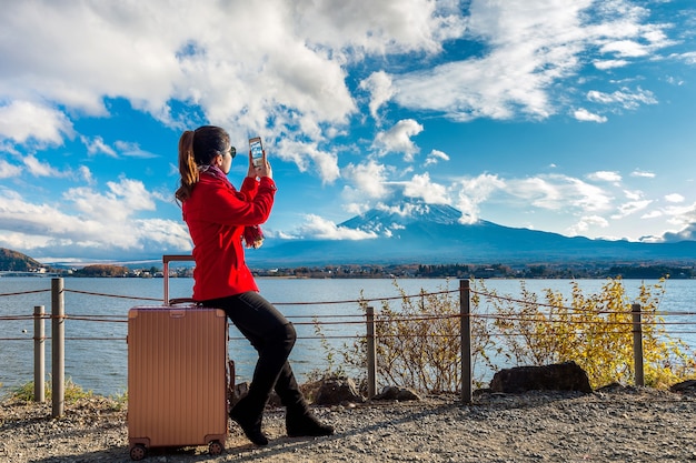 La donna scatta una foto alle montagne fuji. autunno in giappone. concetto di viaggio.