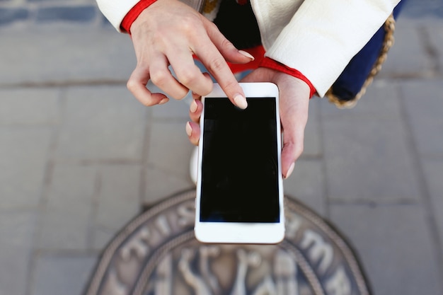 女性は電話で彼女の足の写真を撮る