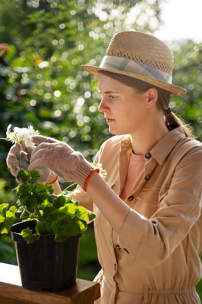 屋外の植物の世話をする女性の側面図