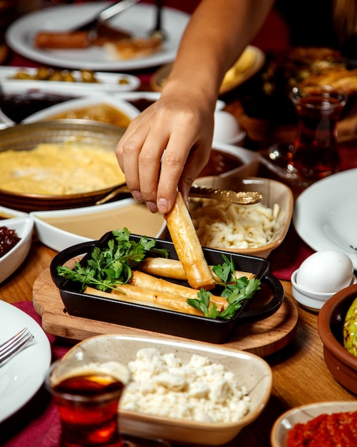 Free photo woman taking finger flatbread wrap from the plate served for breakfast