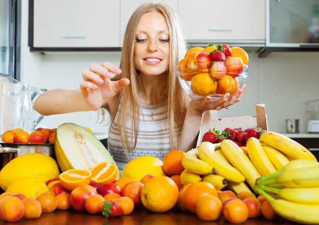 woman taking fruits from table