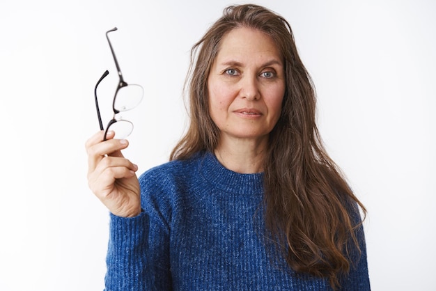 Free photo woman taking of glasses and holding eyewear in hand as looking at camera