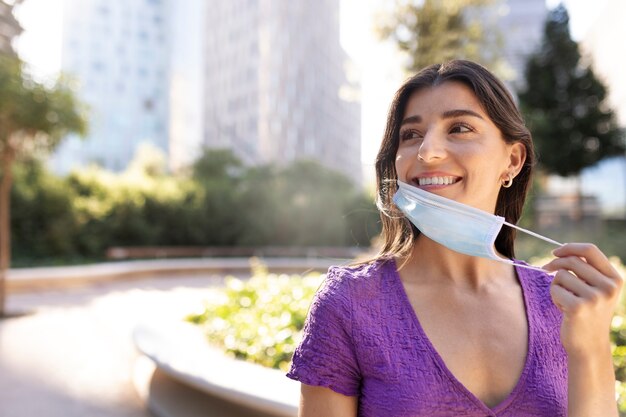 Woman taking mask off medium shot